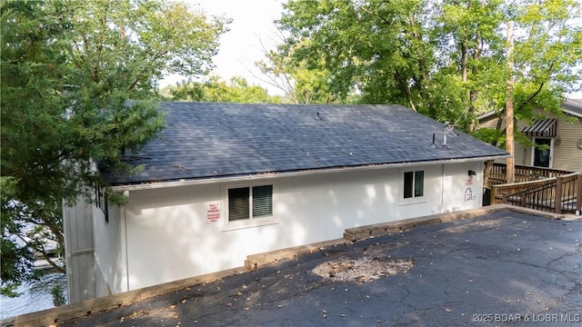 rear view of house featuring a shingled roof