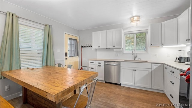 kitchen with range, white cabinets, dishwasher, and a sink