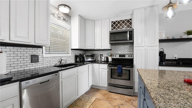 kitchen with tasteful backsplash, white cabinets, stainless steel appliances, and a sink