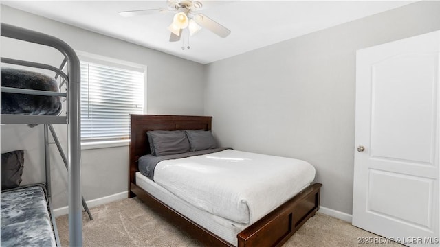 bedroom featuring a ceiling fan, light colored carpet, and baseboards