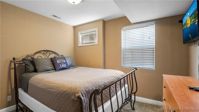 carpeted bedroom with visible vents and baseboards