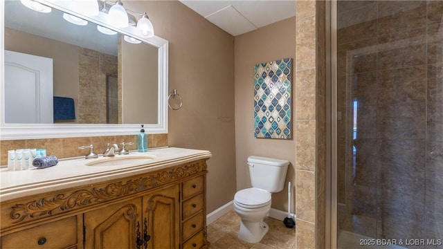 full bathroom with toilet, a shower stall, tile patterned flooring, baseboards, and vanity