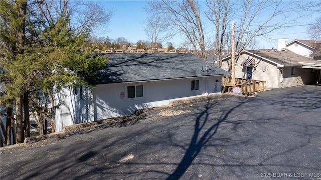 view of property exterior with a deck and driveway