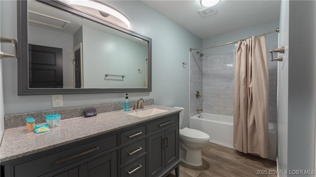 full bath featuring visible vents, shower / tub combo with curtain, toilet, wood finished floors, and vanity