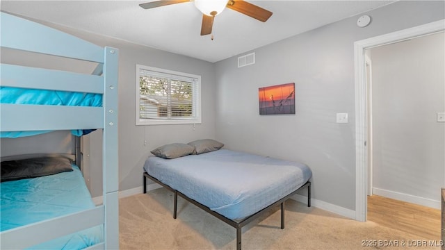 bedroom with light colored carpet, visible vents, baseboards, and ceiling fan