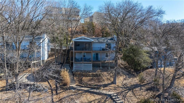 rear view of property featuring stairway