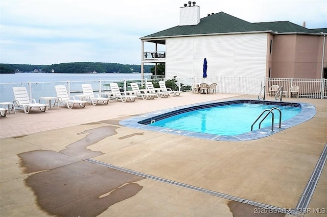 community pool with fence and a patio