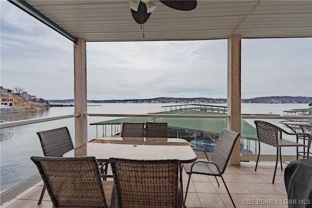 balcony with outdoor dining space, a sunroom, and a water view