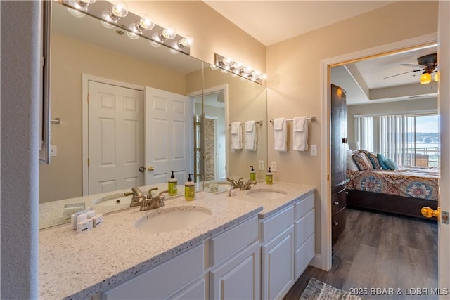 ensuite bathroom with ensuite bathroom, double vanity, wood finished floors, and a sink