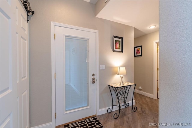 entryway with wood finished floors and baseboards