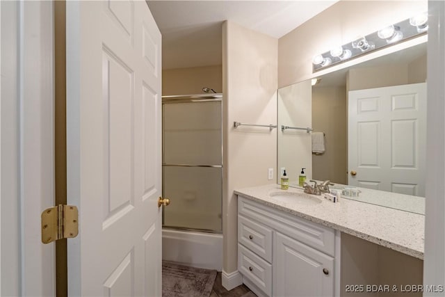 bathroom featuring enclosed tub / shower combo and vanity