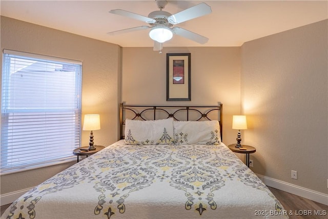 bedroom with ceiling fan, a textured wall, wood finished floors, and baseboards