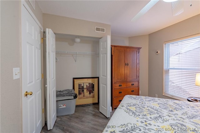 bedroom featuring a ceiling fan, a closet, visible vents, and wood finished floors