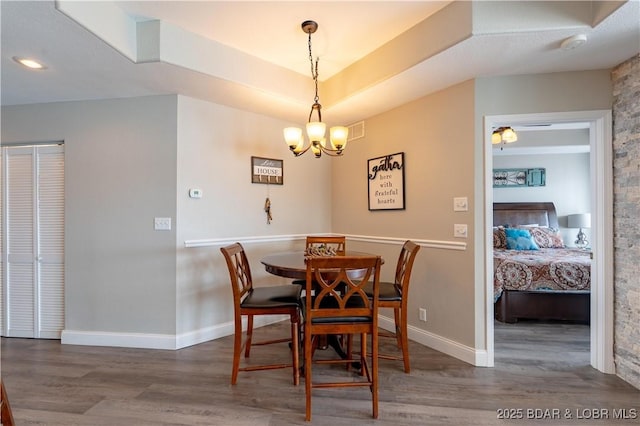 dining area with a notable chandelier, baseboards, and wood finished floors