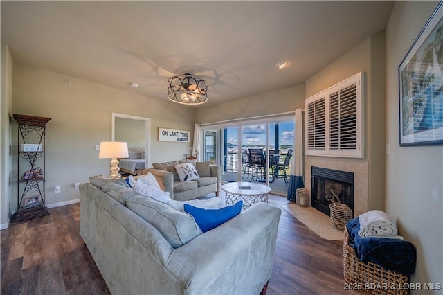 living area featuring wood finished floors, a tile fireplace, and baseboards