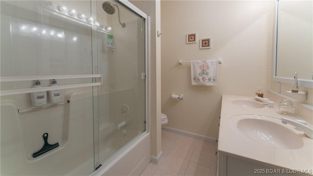 full bathroom with combined bath / shower with glass door, a sink, toilet, and baseboards