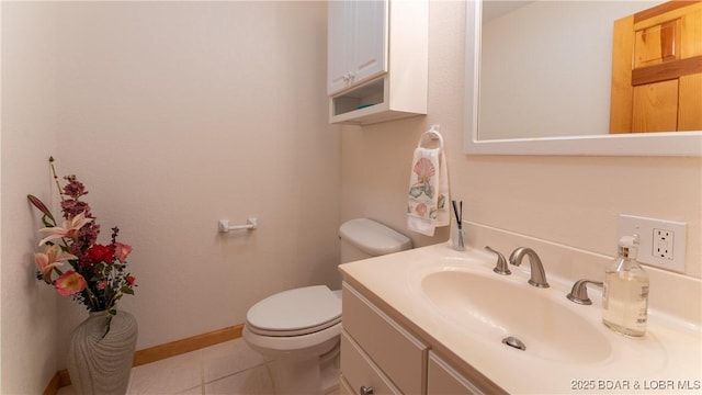 bathroom with toilet, tile patterned flooring, baseboards, and vanity