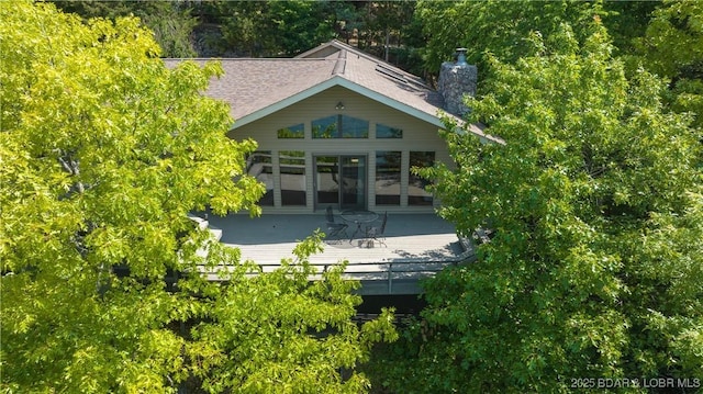 rear view of house with a chimney and a wooden deck