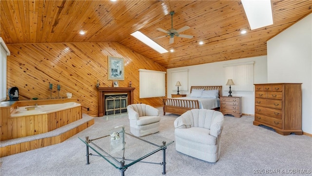 bedroom featuring vaulted ceiling with skylight, carpet, a glass covered fireplace, and wooden ceiling