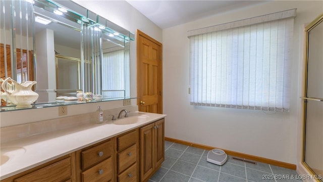 bathroom with a sink, visible vents, tile patterned floors, double vanity, and an enclosed shower