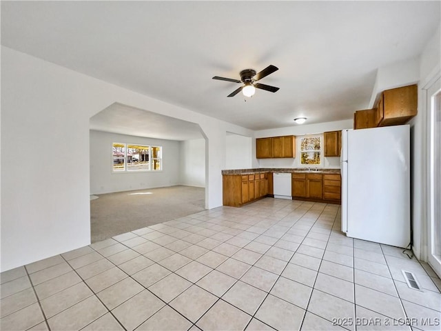 kitchen featuring ceiling fan, white appliances, visible vents, open floor plan, and brown cabinetry