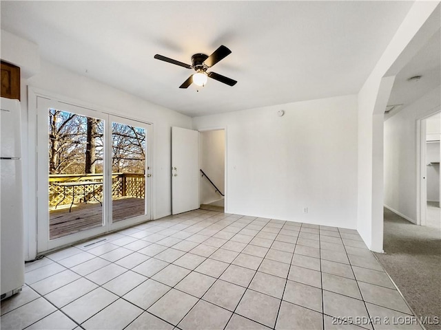 spare room with light tile patterned floors and a ceiling fan