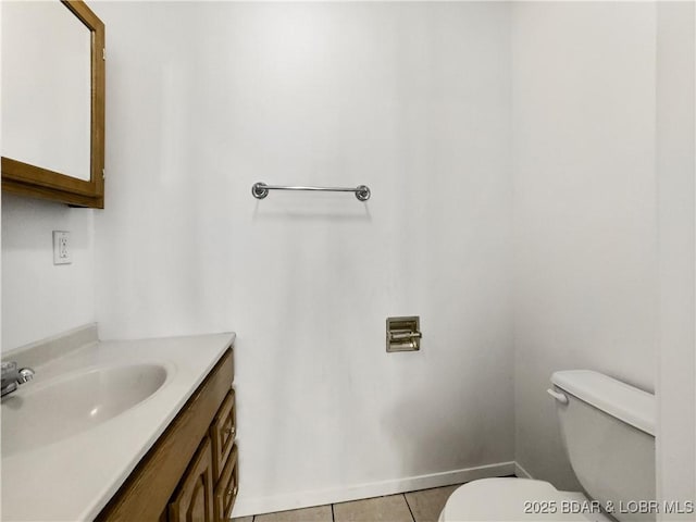 bathroom featuring tile patterned flooring, baseboards, vanity, and toilet