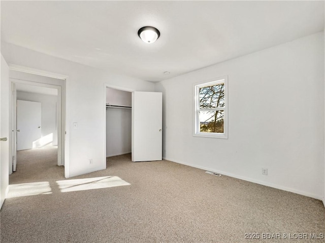 unfurnished bedroom featuring a closet, carpet flooring, and baseboards