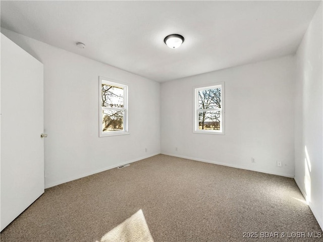 unfurnished room with plenty of natural light and carpet flooring