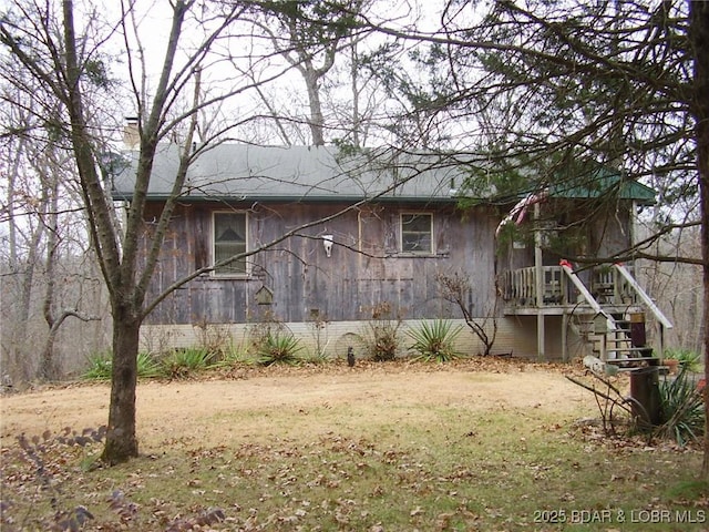 view of side of property featuring stairway and a chimney