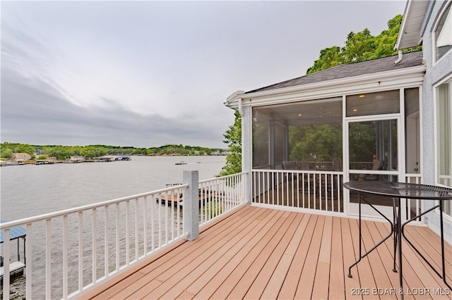 wooden terrace featuring a sunroom and a water view