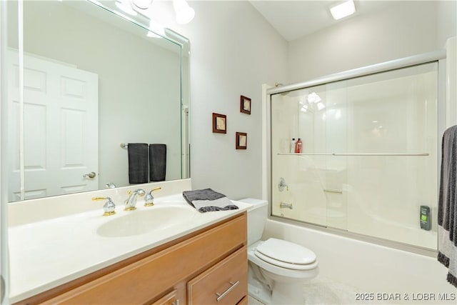 bathroom featuring toilet, enclosed tub / shower combo, and vanity