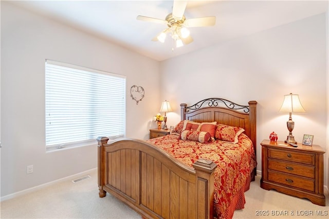 bedroom with light carpet, ceiling fan, visible vents, and baseboards