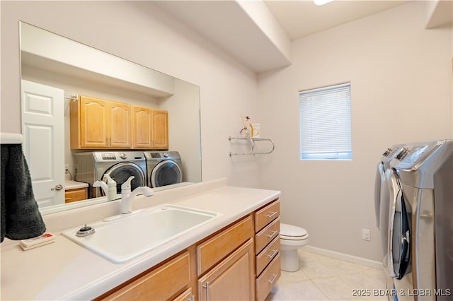 washroom with laundry area, a sink, washer and clothes dryer, and light tile patterned floors