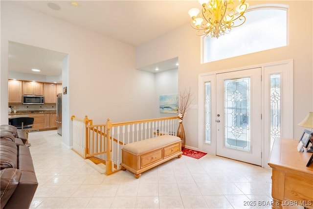 foyer entrance with light tile patterned floors, baseboards, and an inviting chandelier