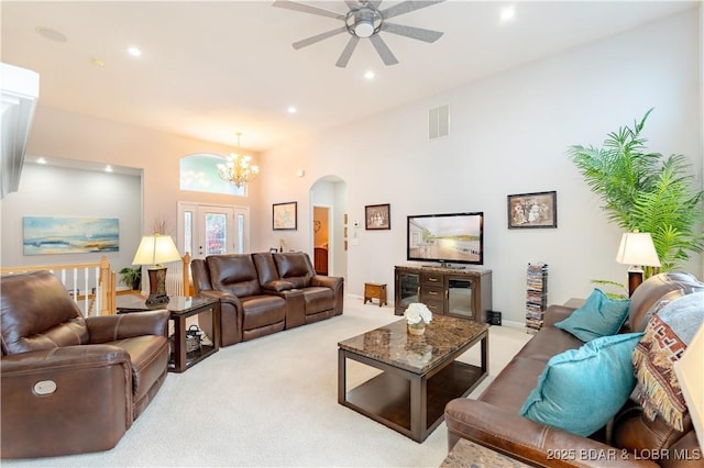 living area with arched walkways, recessed lighting, visible vents, carpet flooring, and ceiling fan with notable chandelier