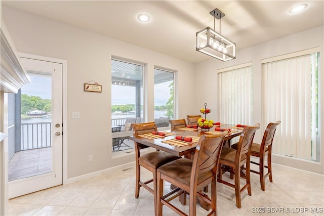 dining area with light tile patterned floors, recessed lighting, a wealth of natural light, and baseboards