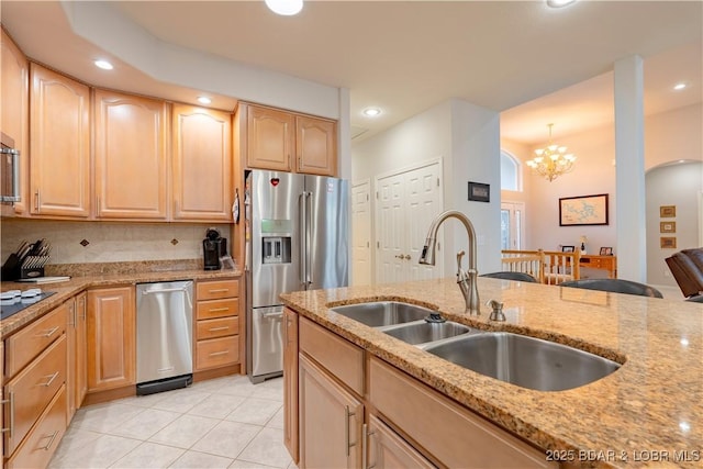 kitchen featuring light tile patterned floors, light stone counters, light brown cabinetry, stainless steel refrigerator with ice dispenser, and a sink