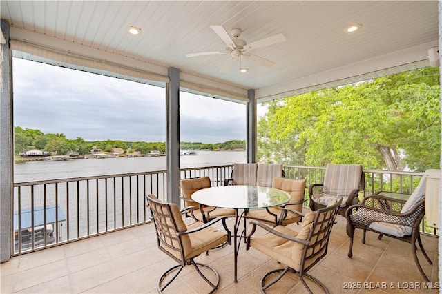 sunroom with a water view and a ceiling fan