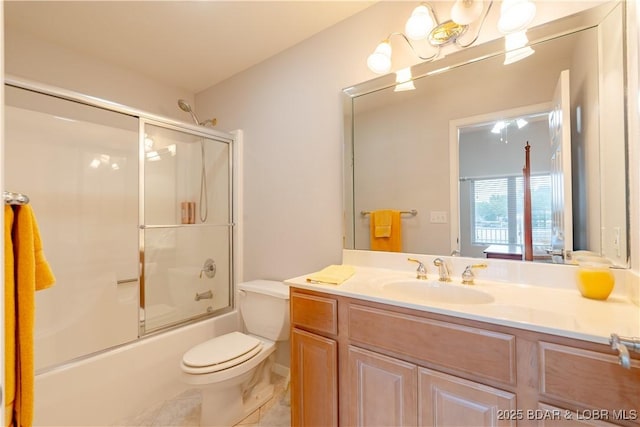 full bathroom with toilet, combined bath / shower with glass door, and vanity