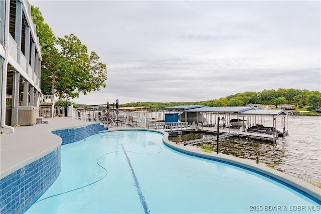 view of swimming pool with a boat dock, a water view, and a fenced in pool