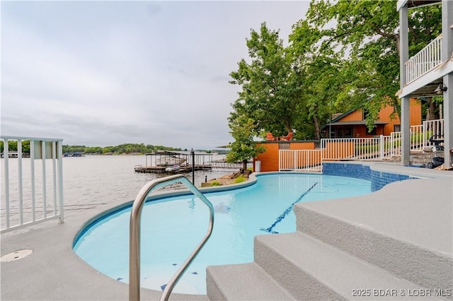 outdoor pool featuring a water view and fence