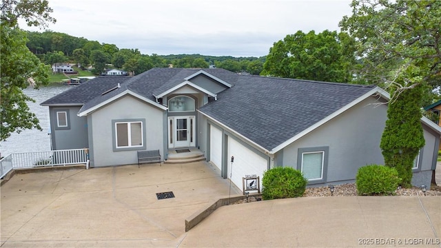 single story home with a shingled roof, concrete driveway, an attached garage, and stucco siding