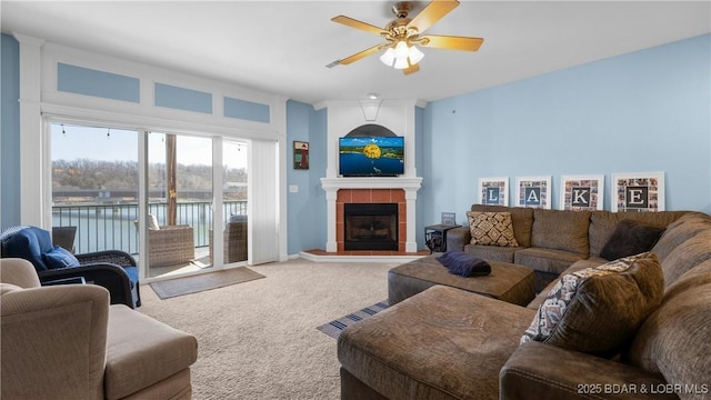 carpeted living area featuring ceiling fan and a fireplace