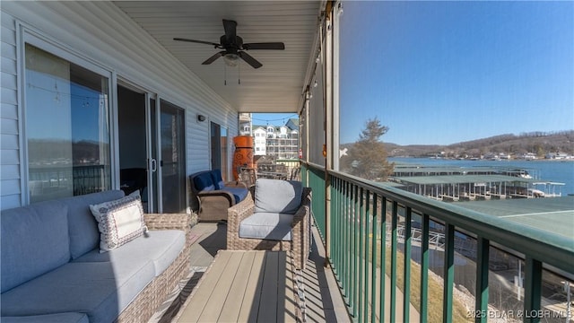 balcony featuring a water view, ceiling fan, and an outdoor hangout area