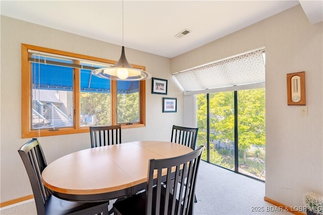 carpeted dining room with visible vents and baseboards