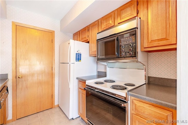 kitchen with light tile patterned floors, white electric range oven, dark countertops, black microwave, and wallpapered walls