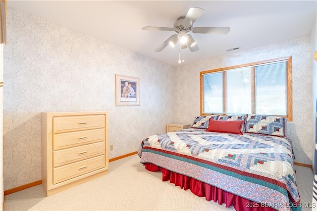 carpeted bedroom featuring baseboards, ceiling fan, visible vents, and wallpapered walls