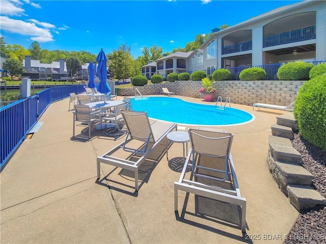 community pool with fence and a patio