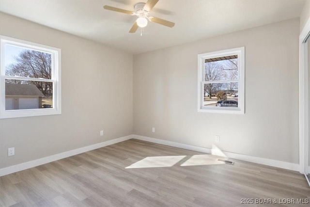 spare room featuring ceiling fan, baseboards, and wood finished floors